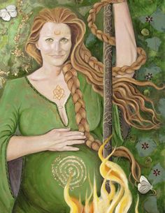 A woman with long, red, braided hair and a green dress stands with one hand on her pregnant belly, the other hand holding a carved staff beside her. A bowl of fire rests before her. Her forehead bears a golden moon crescent, her chest has a golden Celtic knot on it, and her rounded belly has a golden spiral.