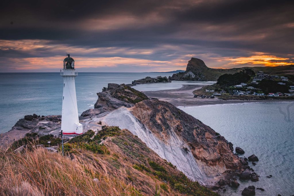 A white lighthouse on a rugged New Zealand cape.
